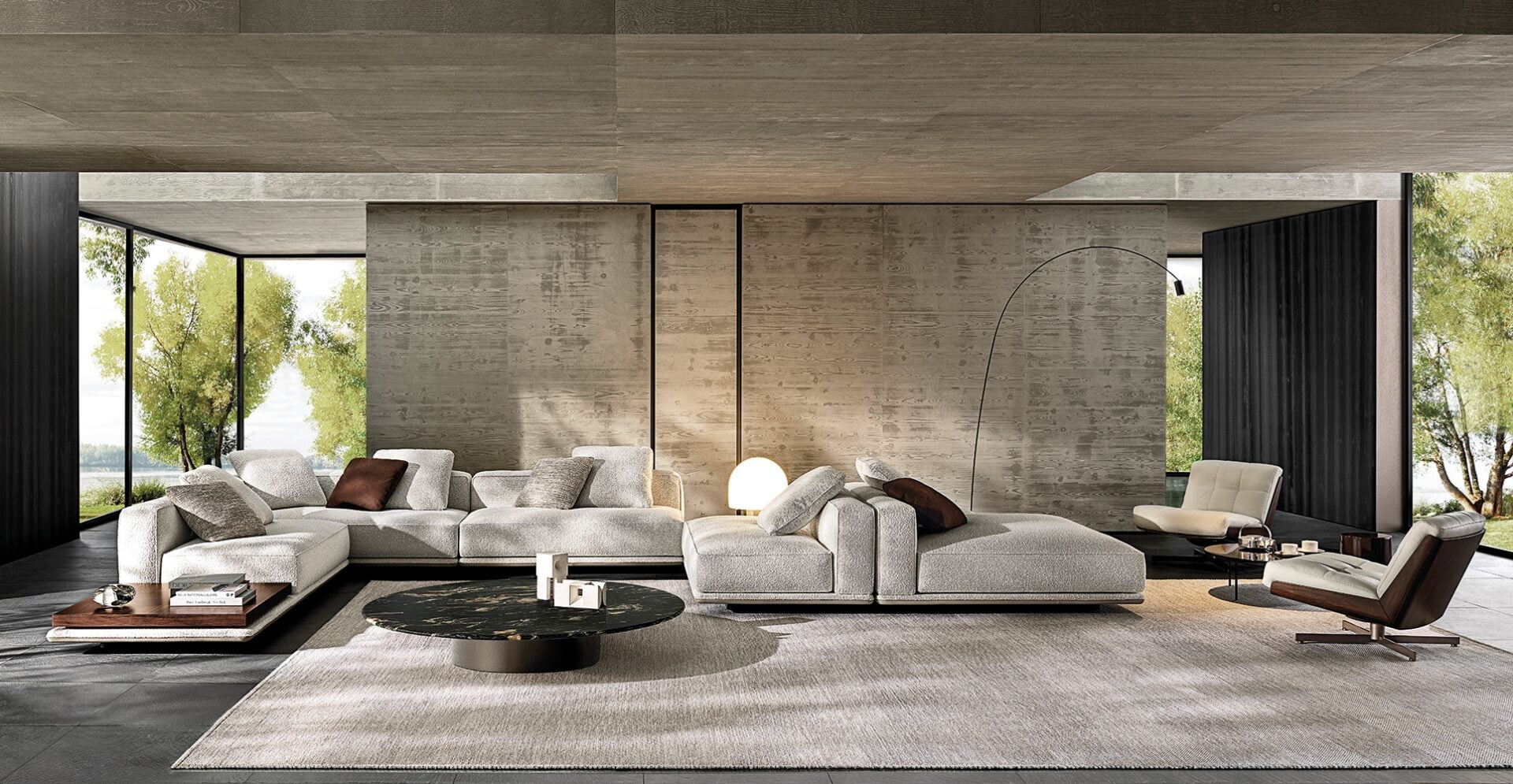 Minotti Horrizonte in lichte stof gecombineerd met Daiki fauteuils groot kleed en betonnen muur op de achtergrond