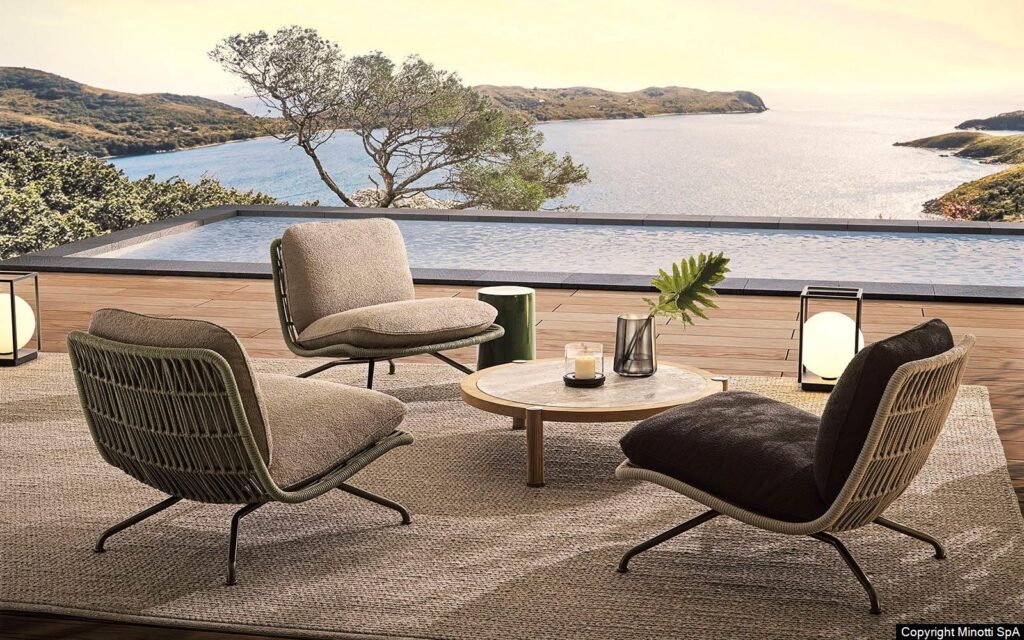 Minotti Pattie Cord outdoor fauteuil sfeerfoto terras infinity pool zeezicht